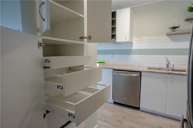 4334 E Ocean Dr Unit 306, Corpus Christi, TX 78404 - kitchen with open shelves, stainless steel dishwasher, white cabinetry, backsplash, and light wood-style flooring