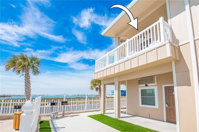 view of patio / terrace with a balcony and a water view