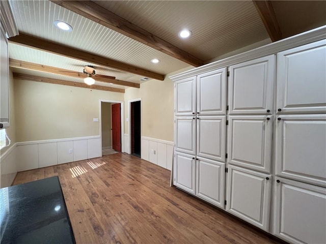 interior space featuring white cabinets, ceiling fan, beam ceiling, and light hardwood / wood-style flooring