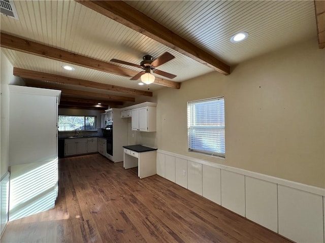 kitchen featuring dark hardwood / wood-style flooring, ceiling fan, sink, beamed ceiling, and white cabinets