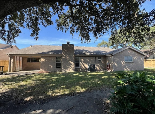 rear view of house with central AC, a patio area, and a yard