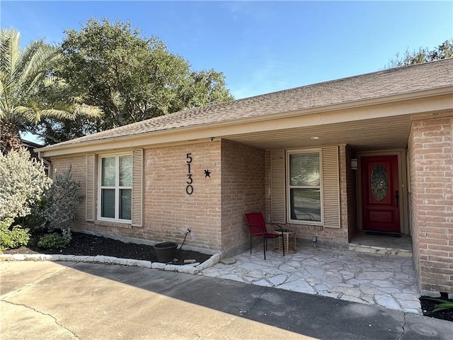 view of exterior entry with a patio