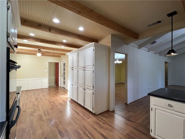 kitchen featuring beam ceiling, white cabinetry, and hanging light fixtures