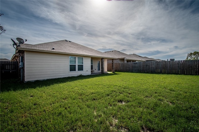 rear view of house featuring a lawn