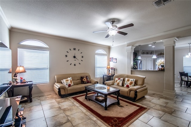 living room featuring ceiling fan, a healthy amount of sunlight, a textured ceiling, and crown molding