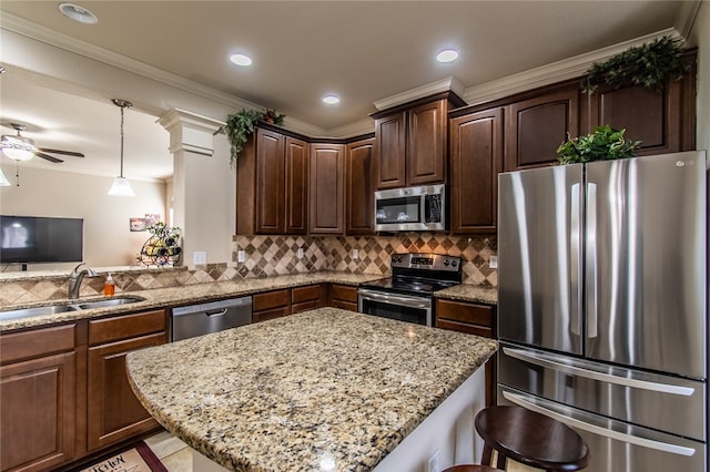 kitchen with stainless steel appliances, sink, a breakfast bar, light stone counters, and ornamental molding