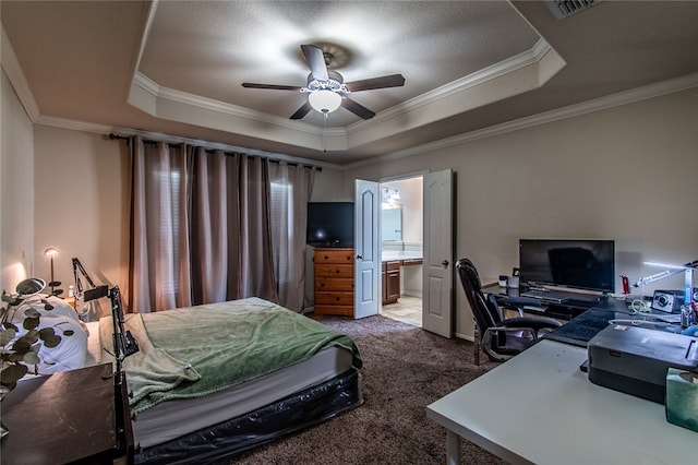 carpeted bedroom featuring ceiling fan, crown molding, a tray ceiling, and connected bathroom