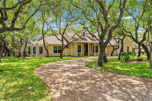 414 Olympic Dr, Rockport, TX 78382 - single story home with fence, a front lawn, curved driveway, and stucco siding