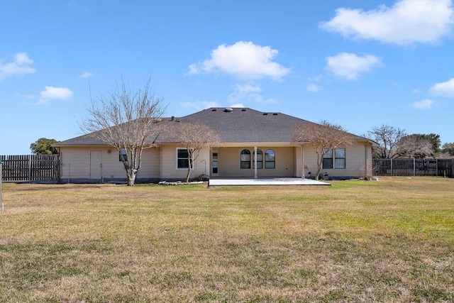 rear view of property featuring a patio, a lawn, and fence