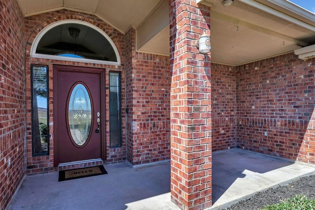 property entrance featuring brick siding