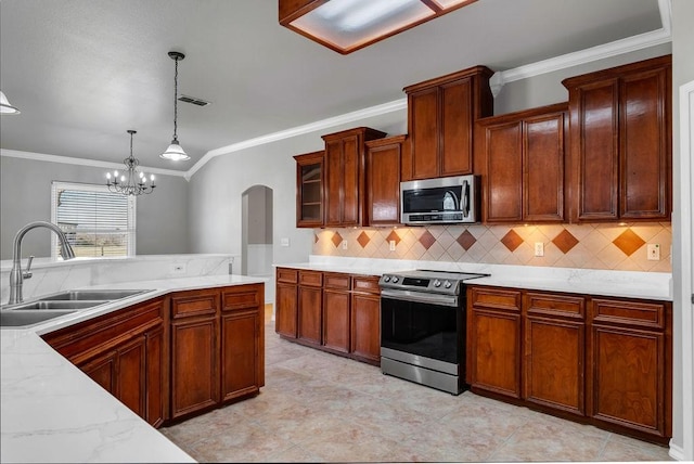 kitchen with stainless steel appliances, visible vents, hanging light fixtures, decorative backsplash, and a sink