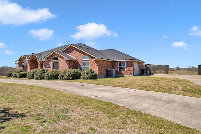 ranch-style house with cooling unit, a garage, brick siding, driveway, and a front yard