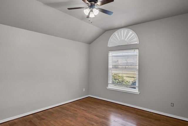 spare room featuring vaulted ceiling, wood finished floors, a ceiling fan, and baseboards