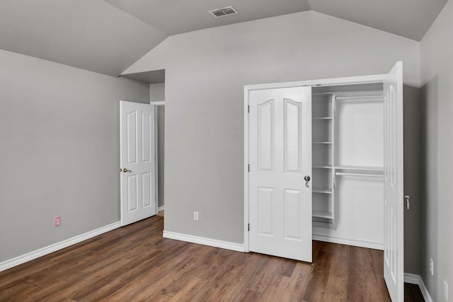 unfurnished bedroom with lofted ceiling, baseboards, visible vents, and dark wood-style flooring