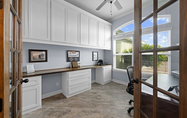 home office with ceiling fan, crown molding, and built in desk