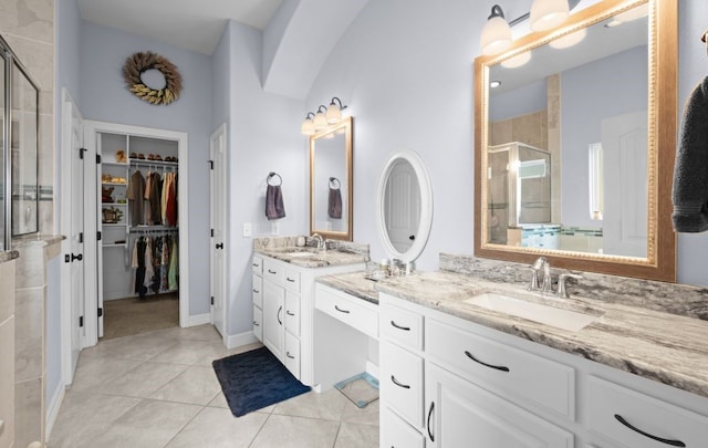 bathroom featuring a shower with shower door, vanity, and tile patterned flooring