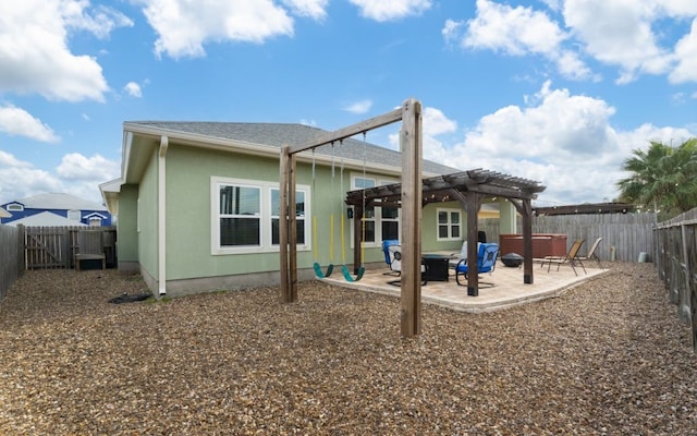 back of house with a pergola, a hot tub, and a patio