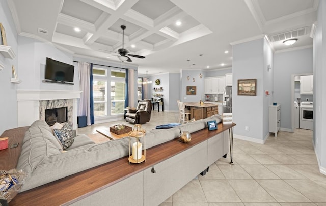 living room featuring coffered ceiling, ceiling fan, a high end fireplace, crown molding, and beamed ceiling