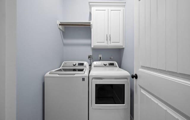 laundry area with washer and dryer and cabinets