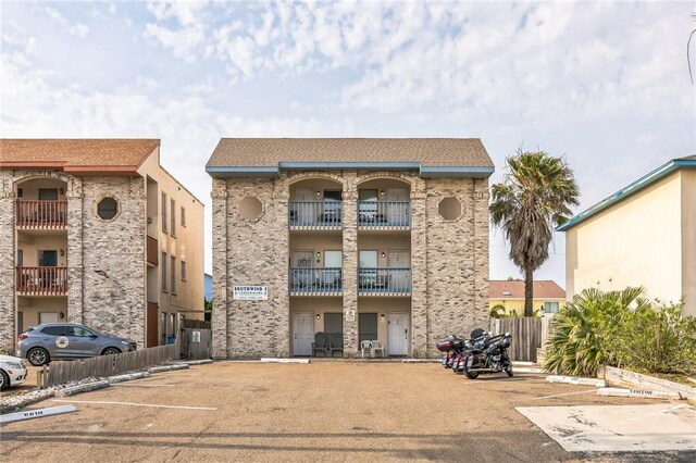 123 E Cora Lee Dr Unit 301, South Padre Island, TX 78597 - view of apartment building / complex with uncovered parking and fence