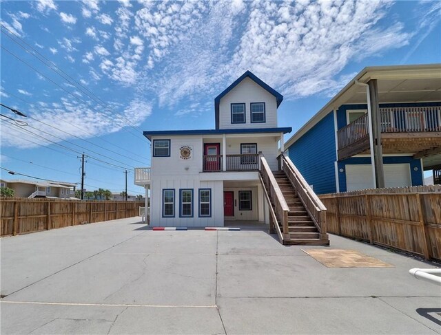 514 Royal Palm Dr, Port Aransas, TX 78373 - rear view of house with stairs, a fenced backyard, board and batten siding, a patio, and a balcony