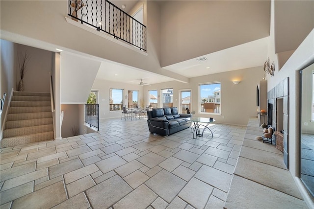 113 Sea Air Ln, Port Aransas, TX 78373 - living room with a towering ceiling, stairway, and a fireplace with raised hearth