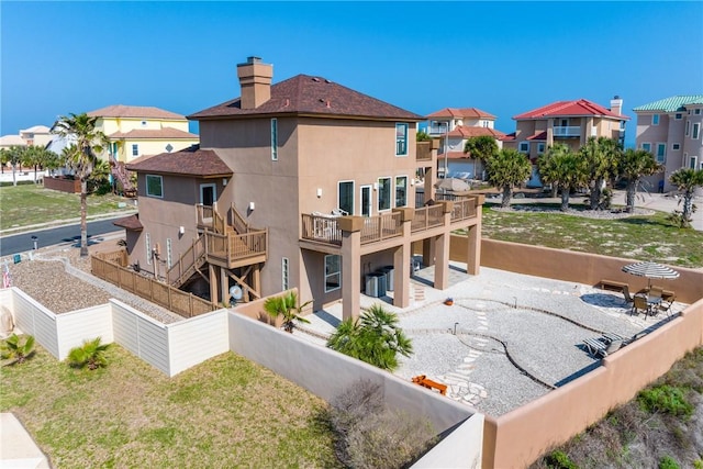 113 Sea Air Ln, Port Aransas, TX 78373 - back of property with stucco siding, a residential view, a patio, and a chimney
