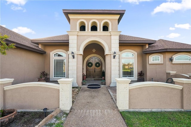8401 Lago Vista Dr, Corpus Christi, TX 78414 - doorway to property with stucco siding and a shingled roof