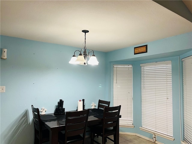 dining area with a chandelier and light tile patterned floors