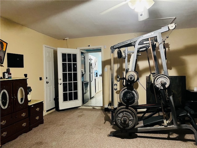 workout area with a textured ceiling, light carpet, and ceiling fan