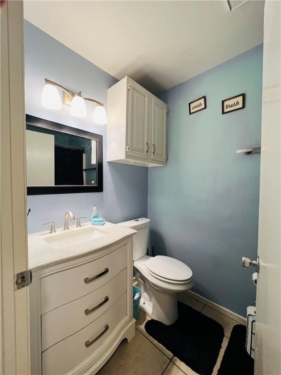 bathroom featuring vanity, tile patterned flooring, and toilet