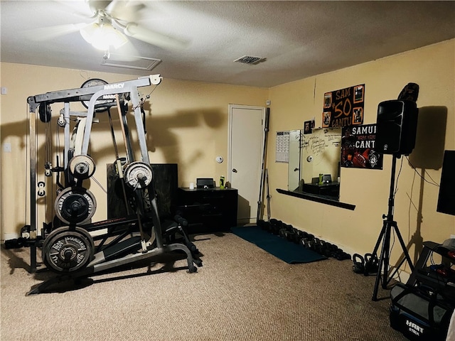 exercise area featuring a textured ceiling, carpet flooring, and ceiling fan