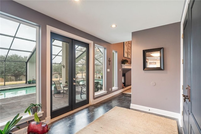 doorway to outside with recessed lighting, baseboards, and finished concrete flooring