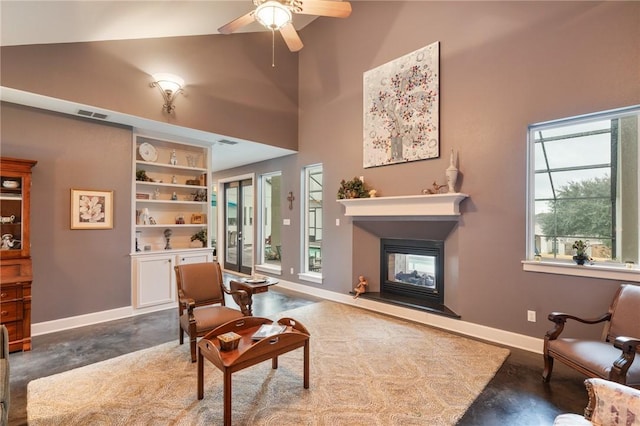 living area with visible vents, concrete floors, baseboards, a multi sided fireplace, and built in features