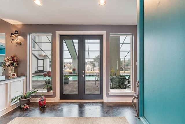 entryway with recessed lighting, french doors, concrete floors, and baseboards