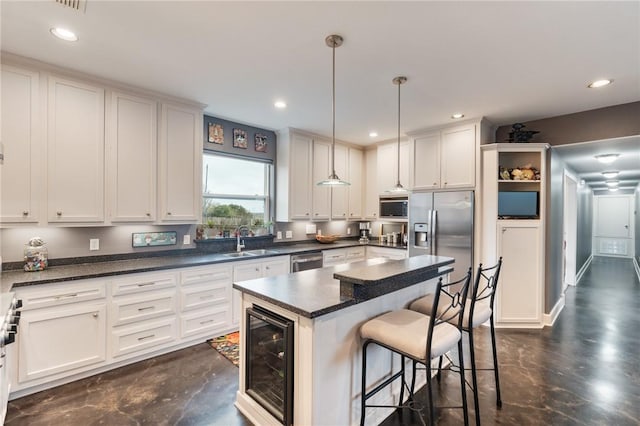 kitchen featuring wine cooler, a breakfast bar area, white cabinets, stainless steel appliances, and a sink