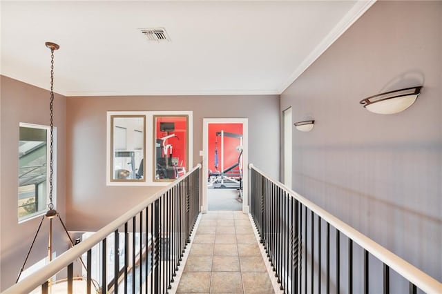 corridor with light tile patterned floors, visible vents, and ornamental molding