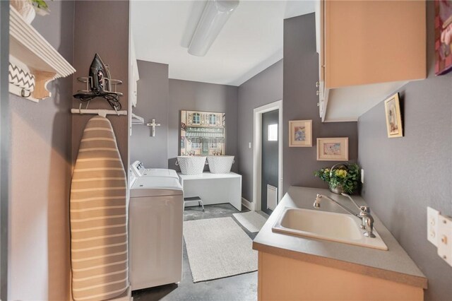 bathroom with separate washer and dryer, concrete floors, and a sink