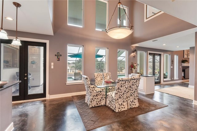 dining area featuring finished concrete floors, plenty of natural light, and baseboards