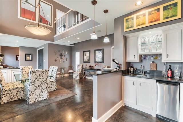 kitchen with dark countertops, finished concrete floors, and stainless steel dishwasher