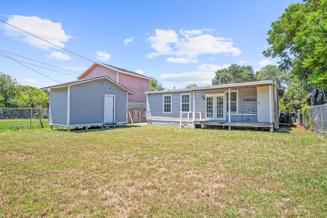 back of house featuring a shed and a lawn