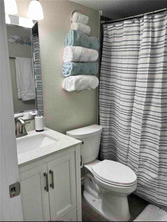 3938 Surfside Blvd Unit 1326, Corpus Christi, TX 78402 - full bathroom featuring vanity, toilet, a shower with shower curtain, and a textured wall