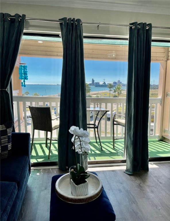 interior space featuring hardwood / wood-style floors, plenty of natural light, a water view, and crown molding