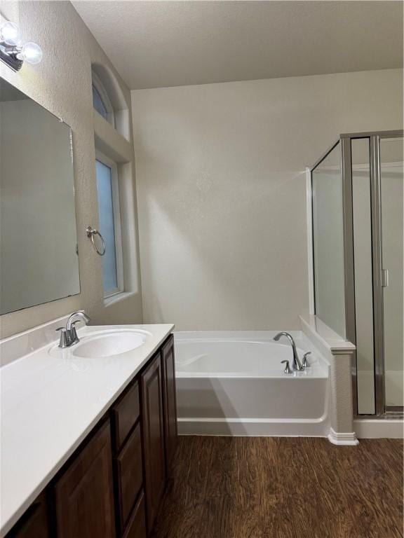 bathroom featuring shower with separate bathtub, wood-type flooring, and vanity