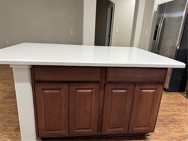 interior details with stainless steel refrigerator with ice dispenser and dark brown cabinets