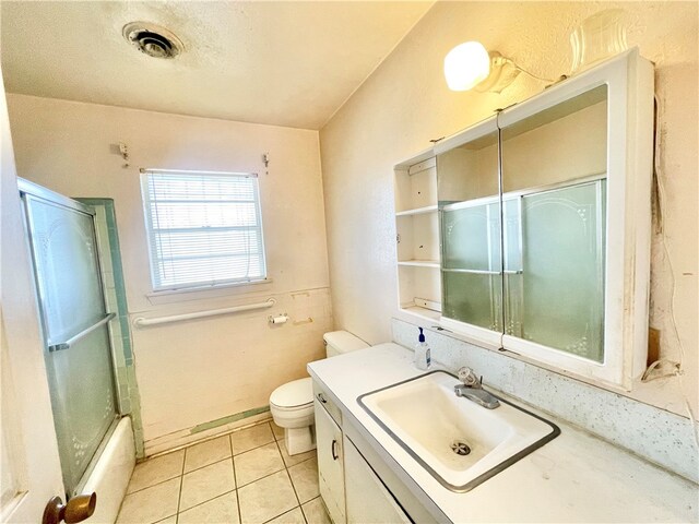 full bathroom featuring tile patterned flooring, shower / bath combination with glass door, toilet, and vanity