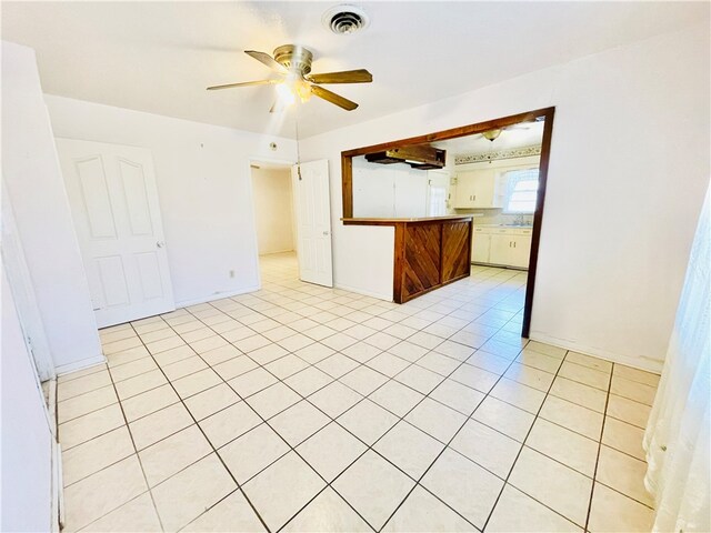 tiled empty room featuring ceiling fan and sink