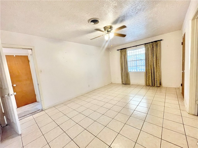 unfurnished room featuring a textured ceiling, light tile patterned floors, and ceiling fan