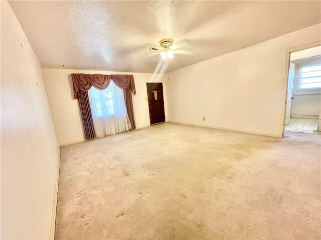 carpeted spare room with a textured ceiling and ceiling fan