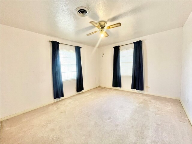 unfurnished room with a textured ceiling, light carpet, and ceiling fan